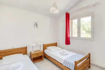 two beds in a room with a window at EL ORO - Terrasse Vue Mer et piscine - Porto Vecchio in Porto-Vecchio
