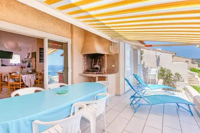 a patio with a blue table and white chairs at EL ORO - Terrasse Vue Mer et piscine - Porto Vecchio in Porto-Vecchio