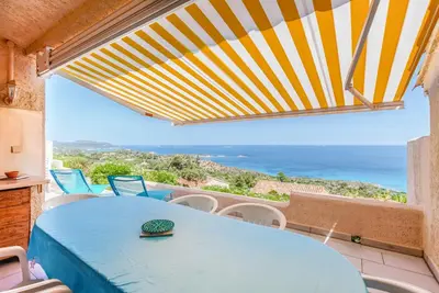 a room with a table and a view of the ocean at EL ORO - Terrasse Vue Mer et piscine - Porto Vecchio in Porto-Vecchio