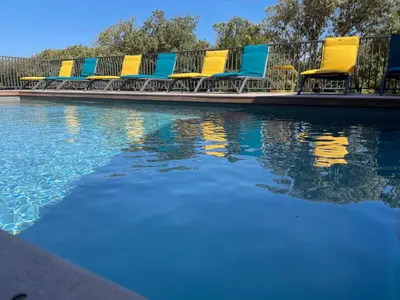 a row of chairs sitting next to a swimming pool at CASE DI A CAPPANA-Villa VINCENT in Bonifacio