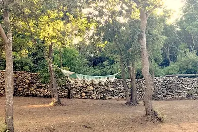 a hammock hanging over a stone wall at CASE DI A CAPPANA-Villa VINCENT in Bonifacio