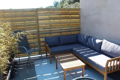 a patio with a couch and a table and chairs at CASE DI A CAPPANA-Villa VINCENT in Bonifacio