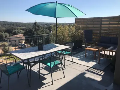 a table and chairs with an umbrella on a patio at CASE DI A CAPPANA-Villa VINCENT in Bonifacio