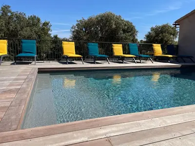 a group of chairs sitting next to a swimming pool at CASE DI A CAPPANA-Villa VINCENT in Bonifacio