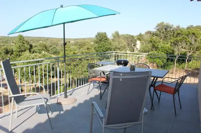 a patio with a table and chairs and an umbrella at CASE DI A CAPPANA-Villa VINCENT in Bonifacio