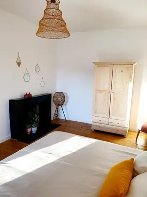 a bedroom with a white bed and a cabinet at Appartement au cœur de Sartene in Sartène