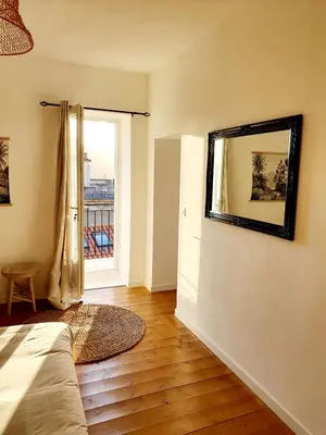 a bedroom with a bed and a mirror on the wall at Appartement au cœur de Sartene in Sartène