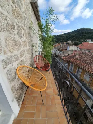 a balcony with two chairs and a view at Appartement au cœur de Sartene in Sartène