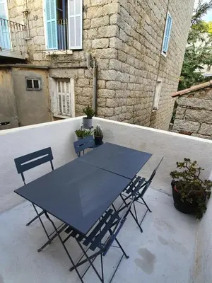 a blue table and chairs on a patio at Appartement au cœur de Sartene in Sartène