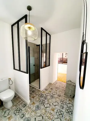 a bathroom with a toilet and a chandelier at Appartement au cœur de Sartene in Sartène