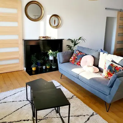 a living room with a blue couch and a fireplace at Appartement au cœur de Sartene in Sartène