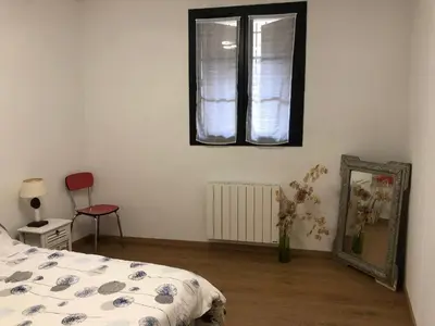 a bedroom with a bed and a mirror and a window at Maison au centre d'un village typique in Omessa