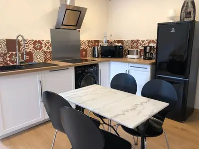 a kitchen with a table and chairs and a microwave at Maison au centre d'un village typique in Omessa
