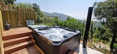 a hot tub sitting on top of a wooden deck at Sottu E Stelle in Albitreccia
