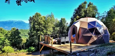 a large tent on a wooden deck with trees at Sottu E Stelle in Albitreccia