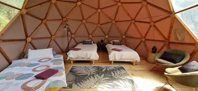 a room with two beds and two chairs in a yurt at Sottu E Stelle in Albitreccia