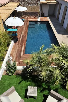 a swimming pool in a yard with a table and an umbrella at clemente en aparté nord in Lecci