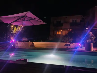 a swimming pool at night with blue and purple lights at RINESA II in Porticcio
