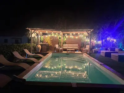 a swimming pool at night with chairs and a couch at RINESA II in Porticcio