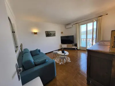 a living room with a blue couch and a tv at Location appartement propriano in Propriano