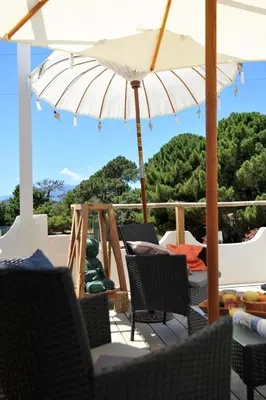 a patio with chairs and an umbrella at Clemente en aparté sud in Lecci