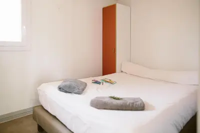 a white bed with two pillows on top of it at Camping Naturiste Riva Bella 4* in Linguizzetta