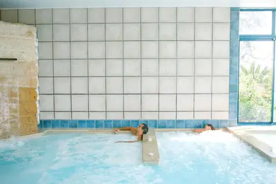 two people swimming in a swimming pool at Camping Naturiste Riva Bella 4* in Linguizzetta