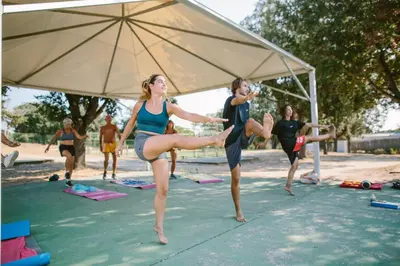 a group of people doing yoga under an umbrella at Camping Naturiste Riva Bella 4* in Linguizzetta