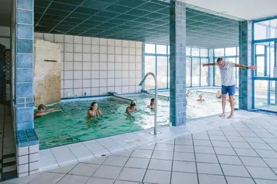 a group of people swimming in a swimming pool at Camping Naturiste Riva Bella 4* in Linguizzetta