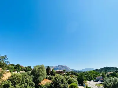 a view of a town with trees and mountains at Propriété Malva appartement agava in Alata