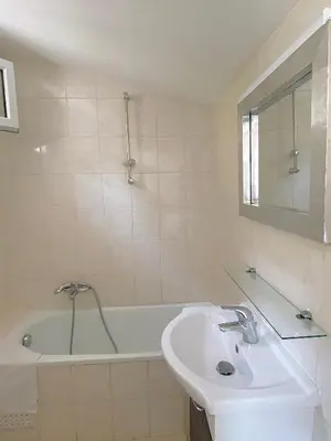 a white bathroom with a sink and a tub at Propriété Malva appartement agava in Alata