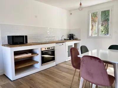 a kitchen with a table and chairs and a microwave at Propriété Malva appartement agava in Alata