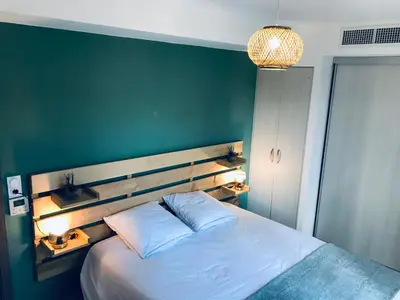 a bedroom with a large bed with a green wall at Résidence Standing Domaine d Arca in Porto-Vecchio