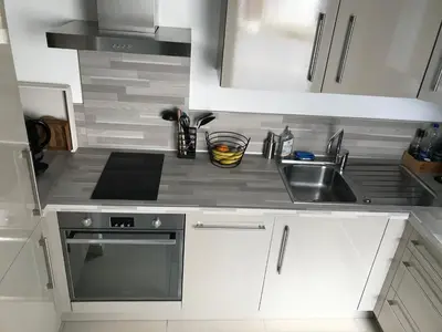 a white kitchen with a sink and a stove at Résidence Standing Domaine d Arca in Porto-Vecchio