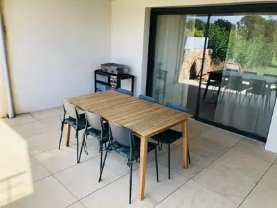 a wooden table and chairs in a room at Résidence Standing Domaine d Arca in Porto-Vecchio