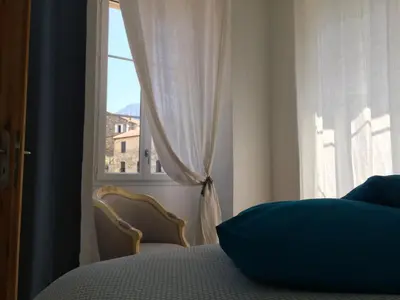 a bedroom with a bed and a window at Casa Mariana in Ghisoni