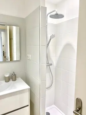 a white bathroom with a shower and a sink at Studio 3 personnes Front de Mer in Tiuccia