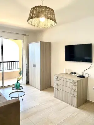 a living room with a cabinet and a tv at Studio 3 personnes Front de Mer in Tiuccia