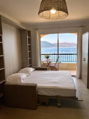 a bedroom with a bed and a view of the ocean at Studio 3 personnes Front de Mer in Tiuccia