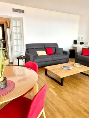 a living room with a couch and a table at Grand T2 STANDING AJACCIO Proche centre et plages VUE PANORAMIQUE PARKING PRIVE in Ajaccio