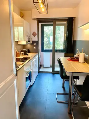 a kitchen with a table and a dining room at Grand T2 STANDING AJACCIO Proche centre et plages VUE PANORAMIQUE PARKING PRIVE in Ajaccio