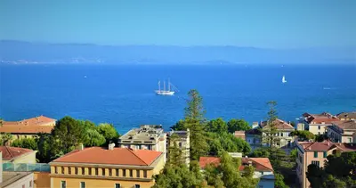 a boat in the water in a city with buildings at Grand T2 STANDING AJACCIO Proche centre et plages VUE PANORAMIQUE PARKING PRIVE in Ajaccio