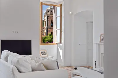 a living room with a white couch and a mirror at Cargèse, appartement de charme surplombant le port in Cargèse