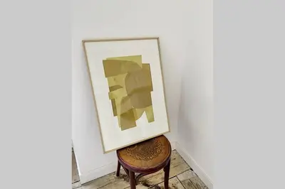 a painting on a wall next to a chair at Cargèse, appartement de charme surplombant le port in Cargèse