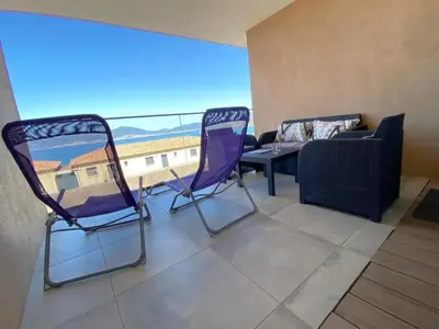 two chairs and a couch in a room with a large window at Appartement vue mer panoramique près de Porticcio in Pietrosella