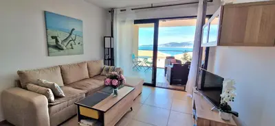 a living room with a couch and a table at Appartement vue mer panoramique près de Porticcio in Pietrosella