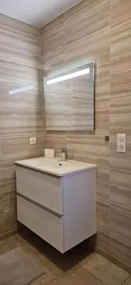 a bathroom with a white sink and a mirror at Appartement vue mer panoramique près de Porticcio in Pietrosella