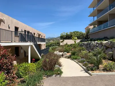 a walkway next to a building with a retaining wall at Appartement vue mer panoramique près de Porticcio in Pietrosella