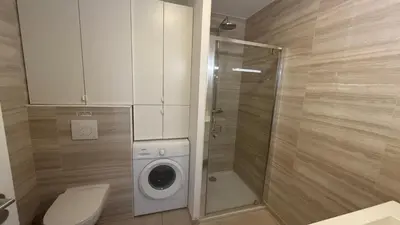 a bathroom with a toilet and a washing machine at Appartement vue mer panoramique près de Porticcio in Pietrosella