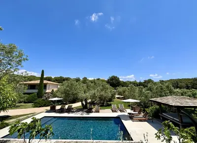 a pool with chairs and umbrellas and a house at Nature & Design in Bonifacio
